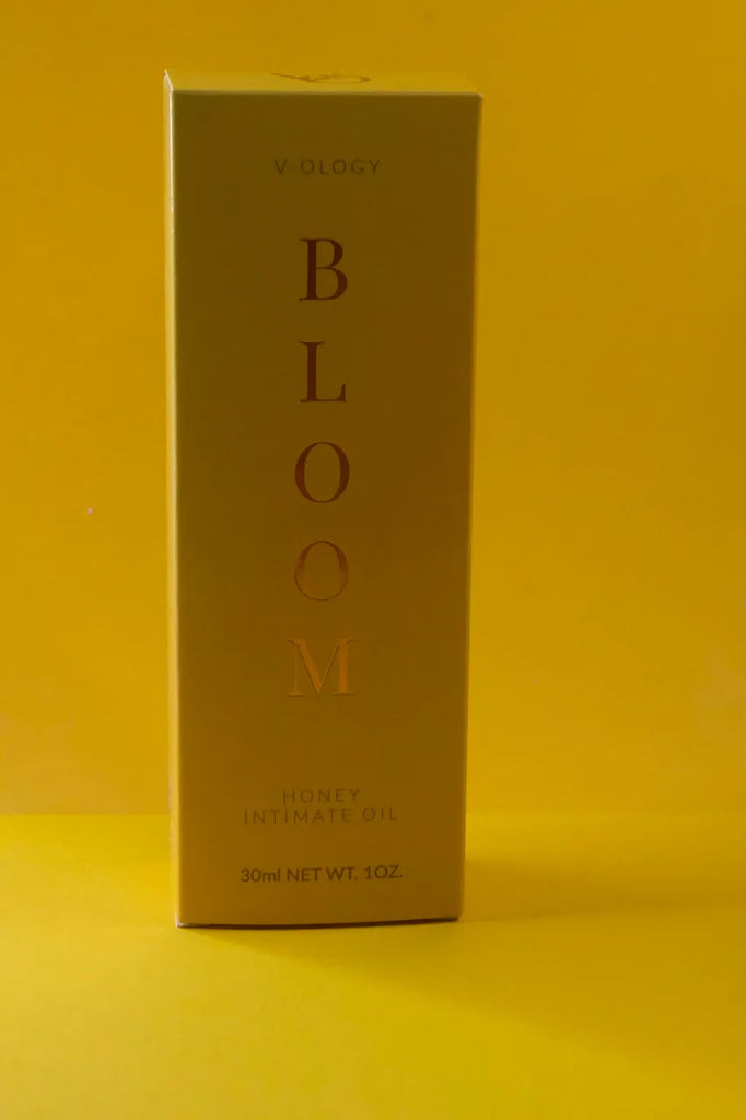 A box of Bloom Honey Intimate Oil for vaginal health on a yellow background.