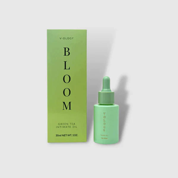A bottle of V-OLOGY Bloom Green Tea Intimate Oil next to a box.