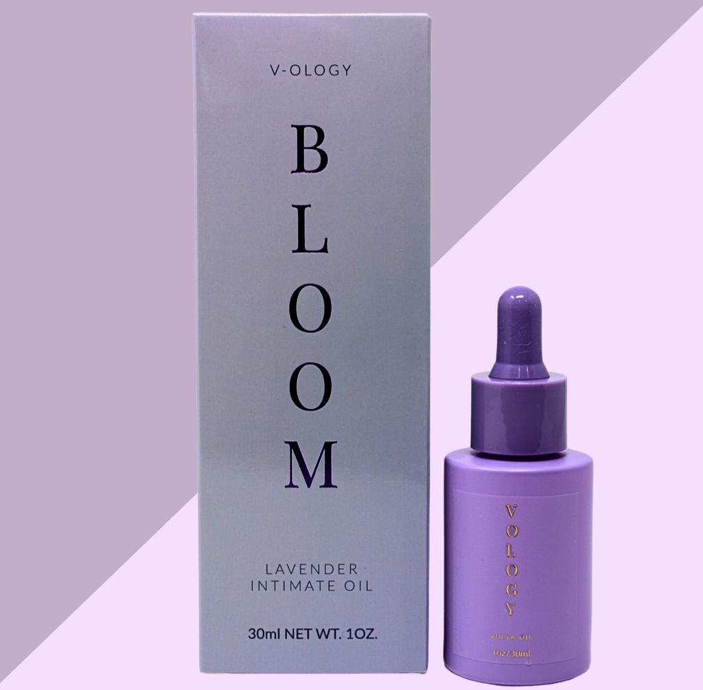A bottle of V-OLOGY Bloom Lavender Intimate Oil next to a purple background.